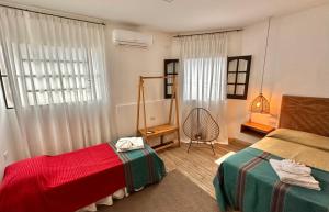 a bedroom with two beds and a chair and a window at Casa Yuri in Salta