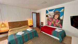 a room with two beds and a painting on the wall at Casa Yuri in Salta