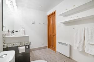 a white bathroom with a sink and a toilet at Accueil Chez Francois in Montréal +60 photos
