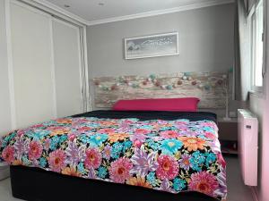 um quarto com uma cama com uma colcha colorida em Luminoso apartamento con precioso y amplio patio em Carabanchel Alto
