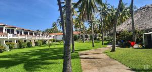 un camino frente a un complejo con palmeras en HOTEL TESORO BEACH, en San Luis La Herradura