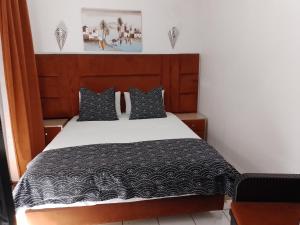 een slaapkamer met een bed met een zwart-wit dekbed bij Un Riad pour se divertir en famille & se détendre in Marrakesh