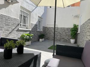 Luminoso apartamento con precioso y amplio patio في Carabanchel Alto: فناء به طاولتين ومظلة