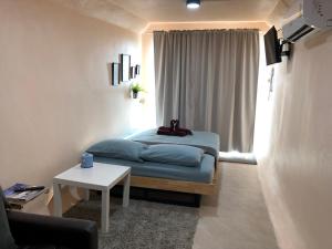 a small bedroom with a bed and a table at Sabai Villa in Ban Nong Wai Khwat