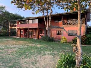 una vista exterior de una casa con patio en Casa Roja Hostel en Montañita