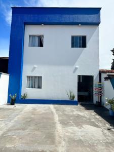 a blue and white building with a driveway at POUSADA E AGENCIA CLEDIO TURISMO in Barreirinhas