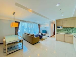 a large living room with a couch and a kitchen at Habitare Apart Hotel Rasuna Jakarta Powered by Archipelago in Jakarta