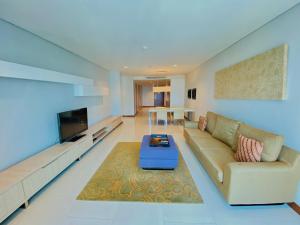 a living room with a couch and a tv at Habitare Apart Hotel Rasuna Jakarta Powered by Archipelago in Jakarta
