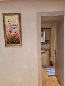 a painting of a flower on a wall next to a kitchen at Appartement Bouznika Bay Golf in Bouznika