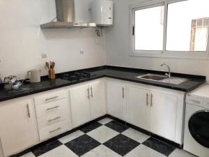 a kitchen with white cabinets and a black counter top at Casa lux in Tetouan