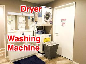 uma lavandaria com uma máquina de lavar roupa e uma máquina de lavar roupa em ゲストハウス888 女性専用ドミトリー em Osaka