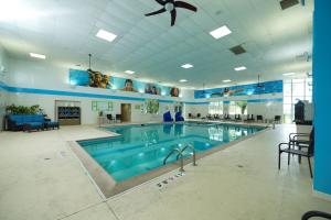 a large swimming pool in a building with a ceiling fan at Holiday Inn & Suites Chicago-Carol Stream Wheaton, an IHG Hotel in Carol Stream