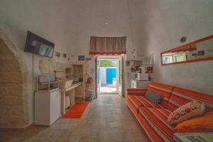 a living room with a red couch and a kitchen at Trulli di Puglia - Casa vacanze in Valle d'Itria in Martina Franca