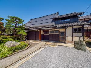 ein japanisches Haus mit einer Einfahrt davor in der Unterkunft Chikubu Yuuan in Nagahama