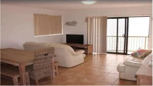 ein Wohnzimmer mit einem Sofa und einem Tisch in der Unterkunft Pacific Breeze - Hosted by Burleigh Letting in Gold Coast