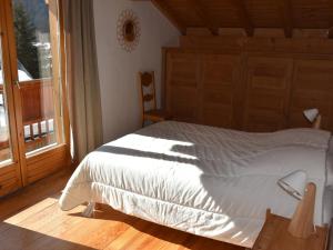 a bedroom with a white bed and a window at Chalet Pralognan-la-Vanoise, 5 pièces, 8 personnes - FR-1-464-176 in Pralognan-la-Vanoise