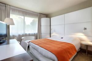 a hotel room with a bed and a television at Mercure Brive in Ussac +31 photos