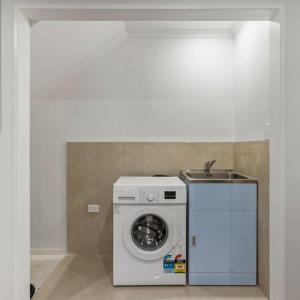 a washer and dryer sitting in a room at Jupiter St Holiday Home No 3 in Auckland