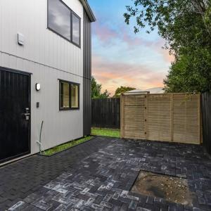 a patio with a fence next to a house at Jupiter St Holiday Home No 3 in Auckland