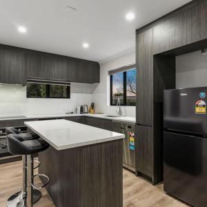 a kitchen with a black refrigerator and a counter at Jupiter St Holiday Home No 3 in Auckland