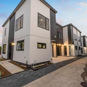 a large white building with windows on a street at Jupiter St Holiday Home No 3 in Auckland