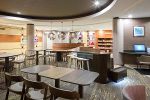 a restaurant with tables and chairs and a library at SpringHill Suites Indianapolis Fishers in Indianapolis