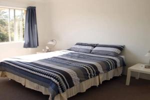 a bed in a white room with a window at Kundu Lodge - Hosted by Burleigh Letting in Gold Coast