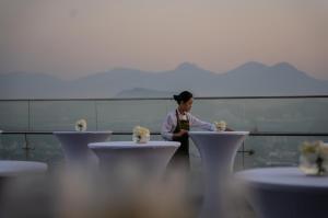 a woman standing in front of tables with flowers on them at Crowne Plaza Vinh Yen City Centre, an IHG Hotel in Yen