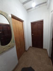 Habitación con 2 puertas y espejo en la pared. en La Termenia en Termas de Río Hondo