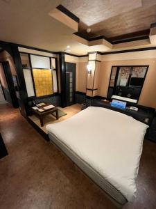 een slaapkamer met een groot wit bed en 2 ramen bij ホテルアンの家 in Ikaho
