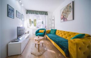 un salon avec un canapé jaune et une télévision dans l'établissement Awesome Apartment In Varazdin With House A Panoramic View, à Varaždin