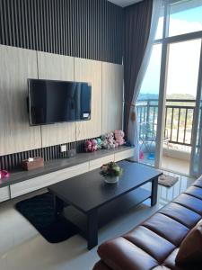 ein Wohnzimmer mit einem Sofa und einem TV an der Wand in der Unterkunft Xing’Formosa Apartement Nagoya in Nagoya