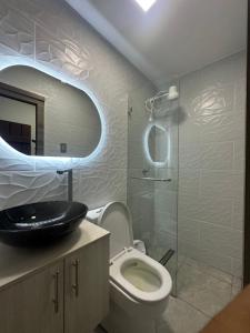 y baño con aseo, lavabo y ducha. en Veranda Apartment, Entre Rios, Samborondon, Ecuador, en Guayaquil