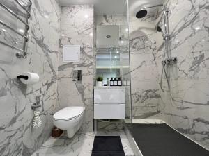 a bathroom with a toilet and a glass shower at Студия в современном стиле in Pavlodar