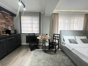 a bedroom with a bed and a table with chairs at Студия в современном стиле in Pavlodar