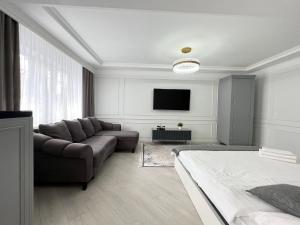 a living room with a couch and a tv at Студия в скандинавском стиле in Pavlodar +4 photos