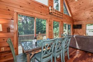 een eetkamer met een glazen tafel en stoelen bij Spectacular Log Cabin Home 45 minutes to Asheville in Marion