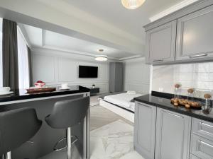 a kitchen with white cabinets and a black counter top at Студия в скандинавском стиле in Pavlodar