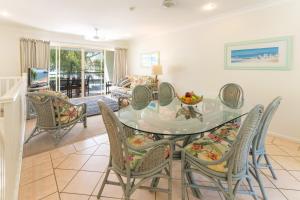 a dining room with a glass table and chairs at Sails On Horseshoe in Horseshoe Bay