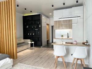 cocina y sala de estar con armarios blancos y sillas blancas en VIP-апартаменты в элитной новостройке. en Pavlodar
