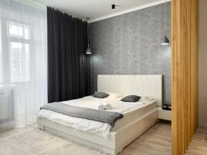 1 dormitorio con 1 cama blanca en una habitación en VIP-апартаменты в элитной новостройке. en Pavlodar