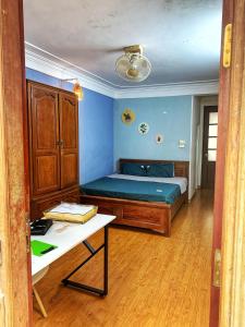 a bedroom with a bed and a table in it at Rainbow HomeStay - No 8 Alley 18B Tong Dan in Hanoi