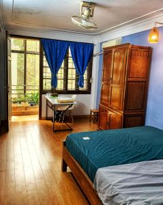 a bedroom with a bed and a dresser and a desk at Rainbow HomeStay - No 8 Alley 18B Tong Dan in Hanoi
