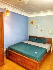 a bed in a bedroom with a blue wall at Rainbow HomeStay - No 8 Alley 18B Tong Dan in Hanoi