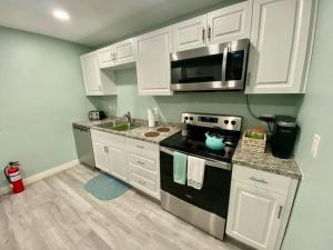 a kitchen with white cabinets and a stove top oven at Serene renovated oasis near downtown area in Gainesville