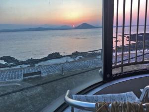 a view of the ocean from a balcony at White Castle Pension in Jeju