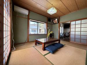 uma sala de estar com uma mesa e uma janela em 下河野旅館ちくさ宍粟市 