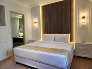 a large white bed in a hotel room at SWISS AVENUE HOTEL in Sungai Petani