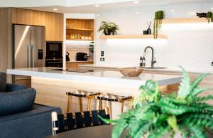 a kitchen with a sink and a counter with stools at BreakFree Royal Harbour in Cairns