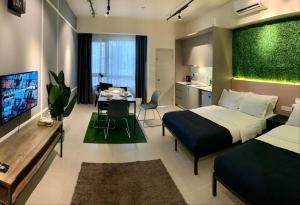ein Schlafzimmer mit einem Bett, eine Küche und ein Wohnzimmer in der Unterkunft Tamarind Suites Cyberjaya in Cyberjaya
